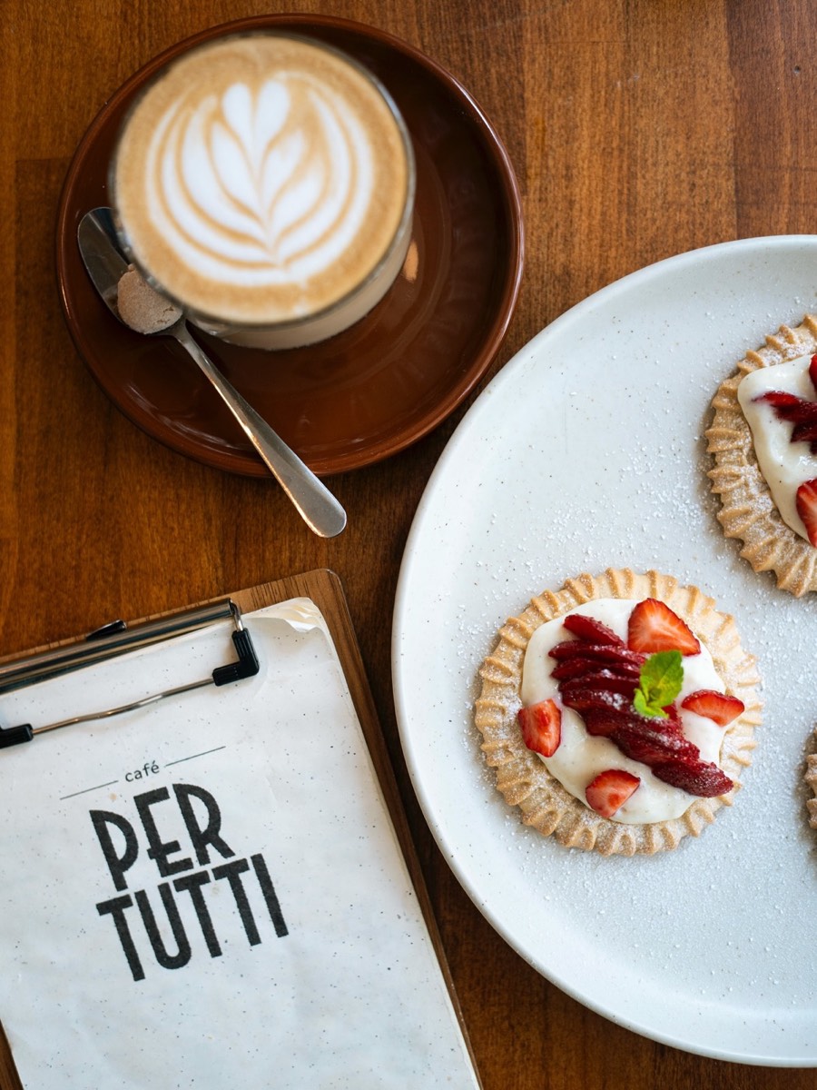 Speisekarte, Cappuccino und Erdbeer-Tartelettes von oben